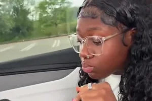 An owner eating out of the tray in her car